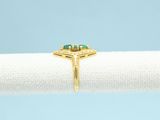 a close up of a gold ring with a green stone