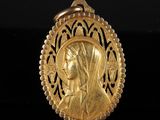 une image représentant un pendentif en or orné du visage d'une femme