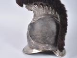 silver helmet with fur on it and a pair of scissors on a white surface