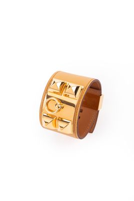un gros plan sur un bracelet en or orné d'une croix