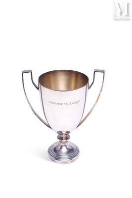 coupe de trophée plaquée argent posée sur un socle, sur fond blanc