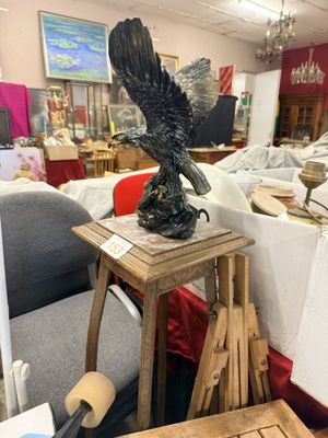 a statue of an eagle sitting on a table in a store
