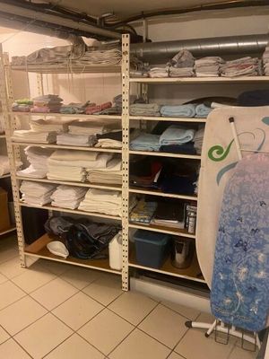 a room with a surfboard and a rack with towels on it