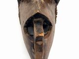 a wooden mask with horns on it on a white background