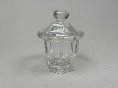 un bocal en verre transparent avec un couvercle, posé sur une surface blanche