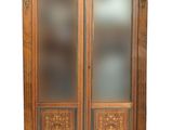 an old wooden cabinet with glass doors and a door handle