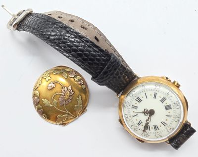 une petite montre et une autre petite montre posées sur une surface blanche