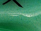 a close up of a green vase with a black ribbon