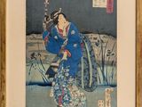 une image représentant une femme vêtue d'un kimono bleu tenant un éventail