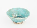 a small blue bowl with a brown rim on a white surface