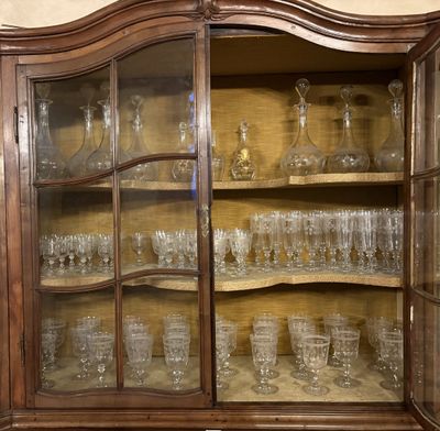 a glass cabinet with a lot of glasses inside of it