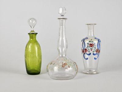 trois vases en verre de couleurs différentes posés l'un à côté de l'autre sur une surface blanche