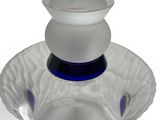 a glass vase with a blue base and a white top