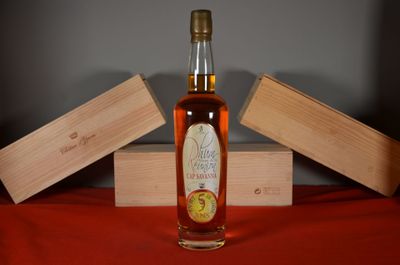 a bottle of whiskey sitting on a table next to two wooden boxes