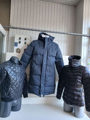 trois manteaux exposés dans la vitrine d'un magasin