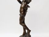 a bronze statue of an angel holding a bird on a rock