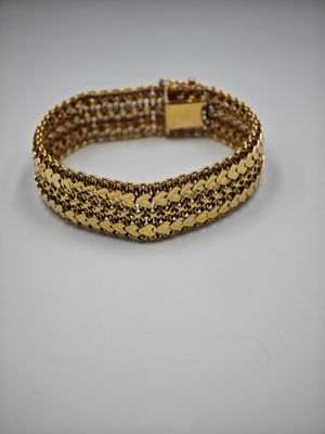 un bracelet composé de perles dorées et noires sur fond blanc