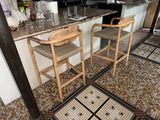deux tabourets en bois posés dans une cuisine, à côté d'un plan de travail