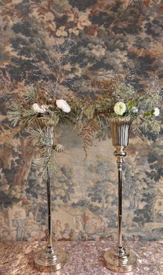 deux vases en argent contenant des fleurs, posés sur une table
