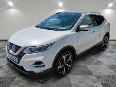 un SUV Nissan blanc garé dans une pièce au sol carrelé