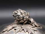 a silver bowl with a flower on top of it