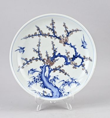 assiette bleue et blanche ornée d'un arbre et d'oiseaux