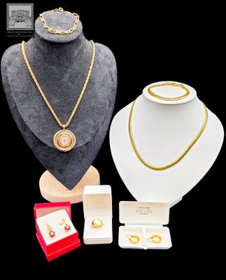 un collier, un bracelet, une bague, des boucles d'oreilles et d'autres bijoux exposés