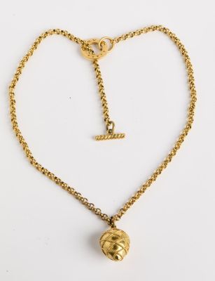 un collier plaqué or avec une boule suspendue à une chaîne