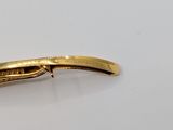 a gold plated knife on a white surface