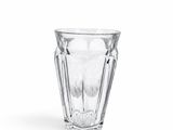 une image représentant un verre d'eau posé sur une surface blanche