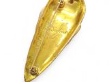 a small gold object on a white surface