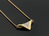 un gros plan d'un collier en or serti de diamants sur un fond noir