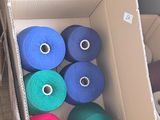 many rolls of yarn in a box on the floor