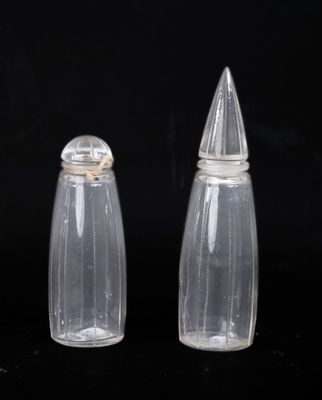 two clear glass salt and pepper shakers on a black background