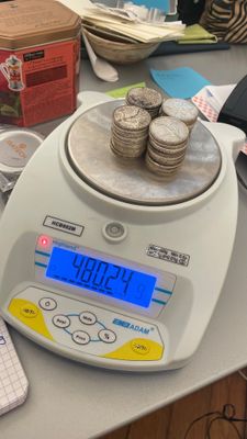 une image représentant une balance sur laquelle sont posées de nombreuses pièces de monnaie