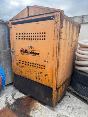 a yellow machine sitting on top of a building next to a pile of tires