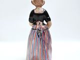 a figurine of a woman in a dress and hat