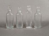 three small glass bottles with a white top and a black bottom