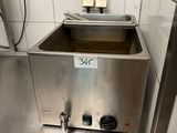 un évier en acier inoxydable dans une cuisine aux murs carrelés