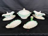 a set of five white and green dishes with green trim