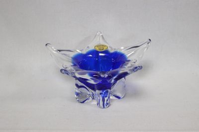 un bol en verre contenant une fleur bleue