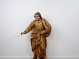 an old wooden statue of a man holding a cane