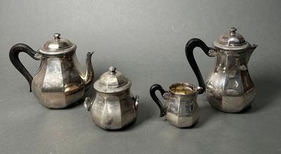 three pieces of silver tea and coffee set on a table