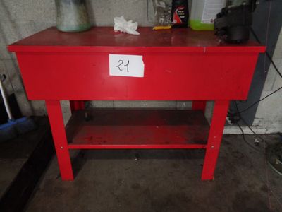 une table rouge sur laquelle est posé un panneau, dans un garage