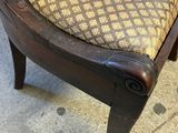 an upholstered foot stool with a patterned seat and wood frame