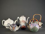 four different types of teapots and a basket on the table