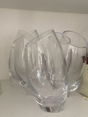 trois verres à vin vides posés sur une étagère à côté d'une bouteille