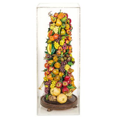 a tall glass vase filled with lots of fruit