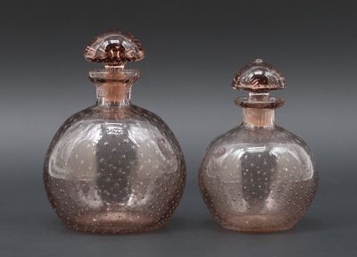 Lot de deux flacons ronds en verre teinté rosé à décor bullé…
