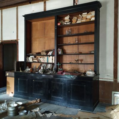une pièce avec une bibliothèque et une table sur laquelle sont posées des assiettes